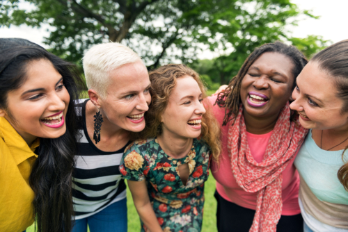 Group of multi-cultural women laughing and smiling at each other